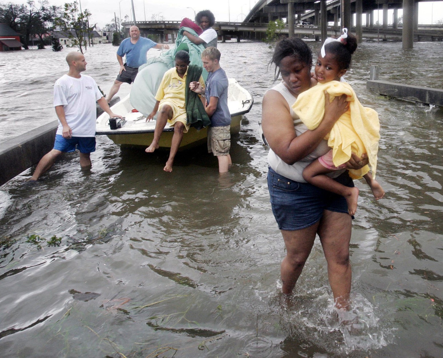 Shante Gruld carries Janeka Garner, 5, to safety after they were rescued from their flooded home by boat  in  New Orleans,  Monday Morning, Aug. 29,  2005. The area was flooded after Hurricane Katrina hit the area. Officials had  called for a mandatory evacuation of the city, but many resident remained in the city.  (AP Photo/Eric Gay)
