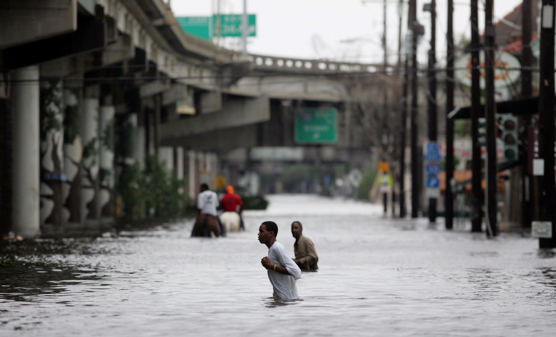 New Orleans residents walk through chest deep floodwater after Hurricane Katrina made landfall on the Louisiana coast on Monday, Aug. 29, 2005. (AP Photo/Dave Martin)