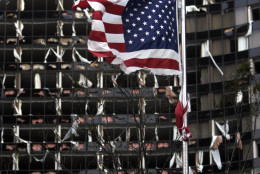 A tattered U.S. Flag flies in the foreground of the Hyatt, in New Orleans, Monday, Aug. 29, 2005, where dozens of windows were blown out when Hurricane Katrina made land fall. ( (AP Photo/Eric Gay)