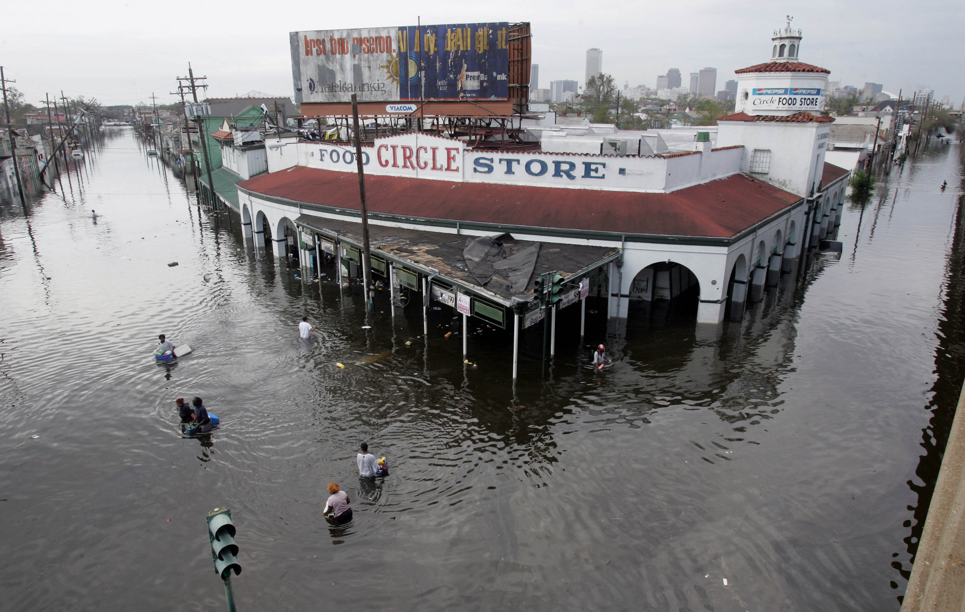 Looters make their way into and out of a grocery store in New Orleans on Tuesday, Aug. 30, 2005.  Flood waters continue to rise in New Orleans after Hurricane Katrina did extensive damage when it made landfall on Monday. (AP Photo/Dave Martin)