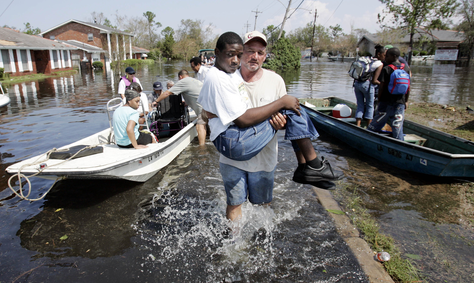 Volunteer Mickey Monceaux carries David Johnson, who could not walk, to safety after he  used his boat to rescue Johnson and other residents from a flooded  neighborhood on the east side of  New Orleans, Wednesday, Aug. 31,  2005. Hurricane Katrina left much of the city under water.  Officials called for a mandatory evacuation of the city, but many residents remained in the city and had to be rescued from flooded homes and hotels.  (AP Photo/Eric Gay)
