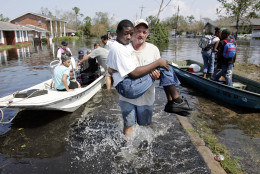 Volunteer Mickey Monceaux carries David Johnson, who could not walk, to safety after he  used his boat to rescue Johnson and other residents from a flooded  neighborhood on the east side of  New Orleans, Wednesday, Aug. 31,  2005. Hurricane Katrina left much of the city under water.  Officials called for a mandatory evacuation of the city, but many residents remained in the city and had to be rescued from flooded homes and hotels.  (AP Photo/Eric Gay)