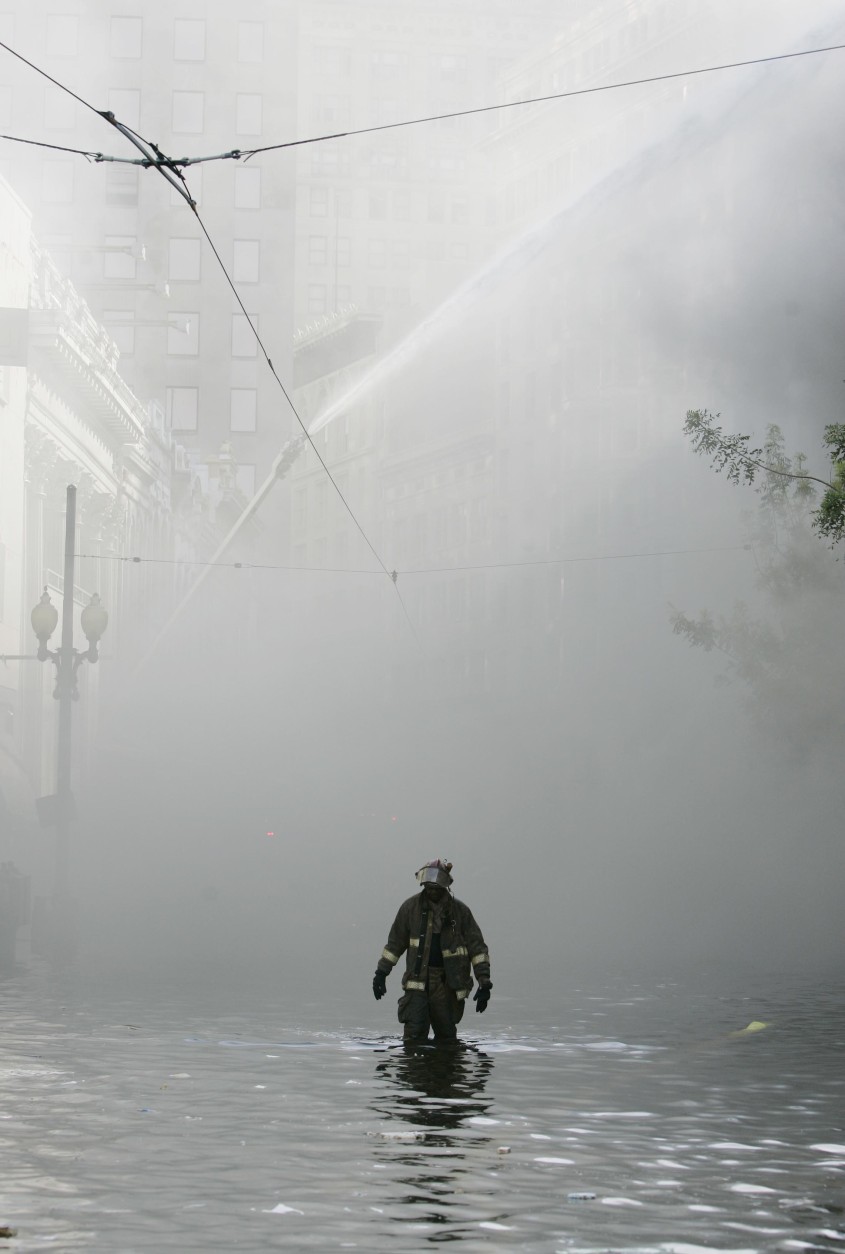 New Orleans firefighters walks through flood water to help battle a building fire in downtown New Orleans, Wednesday, Aug. 31,  2005. Hurricane Katrina left much of the city under water. Officials were uncertain on the cause. (AP Photo/Eric Gay)