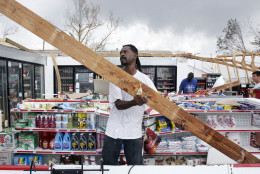 Perry Williams, left, helps a local store owner clean up after his shop was nearly destroyed by Hurricane Katrina in Gulfport, Miss., on Wednesday, Aug. 31, 2005. Residents are still without power or running water following the hurricanes landfall on Monday. (AP Photo/Denis Paquin)