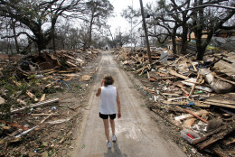 Rhonda Braden walks through the destruction in her childhood neighborhood, Wednesday  Aug. 31, 2005 in Long Beach, Miss. Braden was there checking on her father's house that received major water damage from Hurricane Katrina.  (AP Photo/Rob Carr)