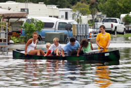 Jordan Hale, front, pulls kids in a canoe through a flooded mobile home park in Florida City, Fla., Friday, Aug. 26, 2005. Hurricane Katrina flooded streets, darkened homes and felled trees as it plowed across South Florida before emerging over the Gulf of Mexico. (AP Photo/Luis M. Alvarez)