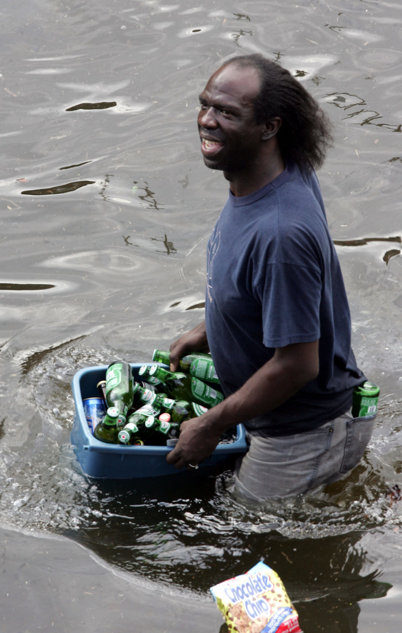 A looter carries a bucket of beer out of a grocery store in New Orleans on Tuesday, Aug. 30, 2005, as floodwaters continue to rise in New Orleans after Hurricane Katrina made landfall on Monday. (AP Photo/Dave Martin)
