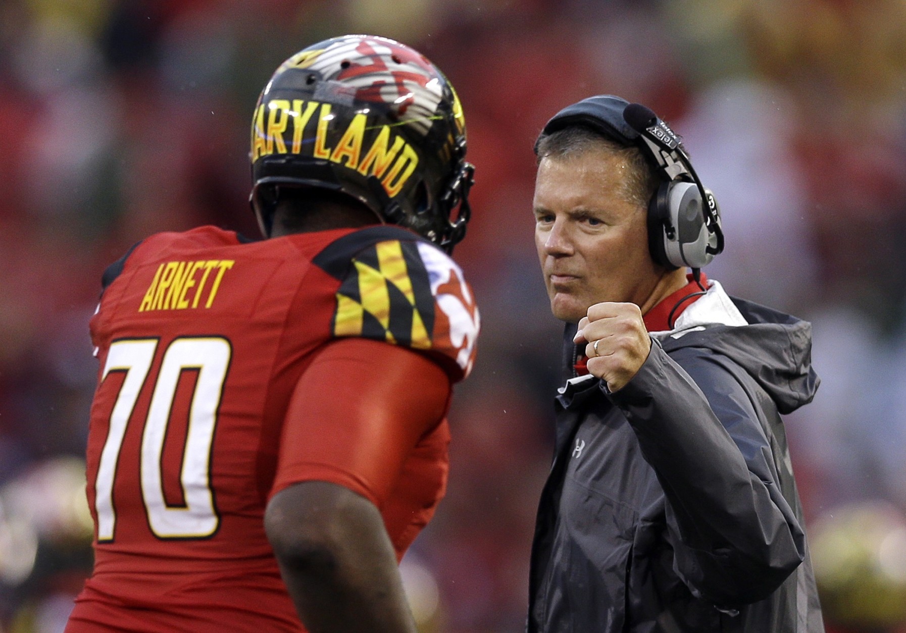 FILE - In this Sept. 21, 2013 file photo, Maryland head coach Randy Edsall fist bumps offensive linesman De'Onte Arnett as he jogs off the field during an NCAA college football game against West Virginia in Baltimore. Maryland won't have to cross the state line for its first bowl appearance since 2010. The Terrapins will face Marshall in the Military Bowl on Dec. 27. The game will be held at the home stadium of the Naval Academy, which is around 28 miles from the Maryland campus. (AP Photo/Patrick Semansky, File)