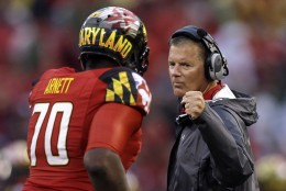 FILE - In this Sept. 21, 2013 file photo, Maryland head coach Randy Edsall fist bumps offensive linesman De'Onte Arnett as he jogs off the field during an NCAA college football game against West Virginia in Baltimore. Maryland won't have to cross the state line for its first bowl appearance since 2010. The Terrapins will face Marshall in the Military Bowl on Dec. 27. The game will be held at the home stadium of the Naval Academy, which is around 28 miles from the Maryland campus. (AP Photo/Patrick Semansky, File)
