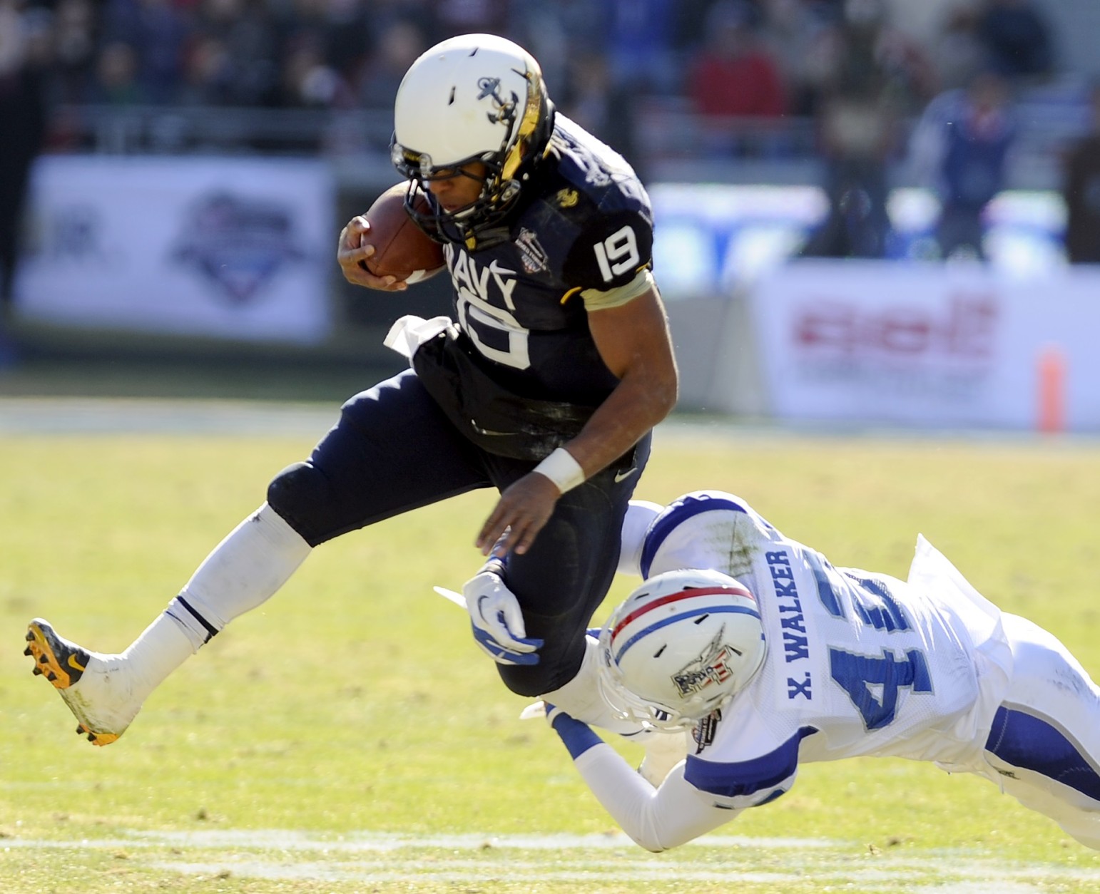 Navy Midshipmen quarterback Keenan Reynolds (19) runs through a tackle attempt by Middle Tennessee Blue Raiders safety Xavier Walker (42) in the first half Armed Forces Bowl NCAA college football game, Monday, Dec. 30, 2013, in Fort Worth. (AP Photo/Matt Strasen)
