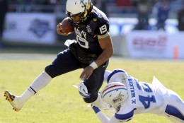Navy Midshipmen quarterback Keenan Reynolds (19) runs through a tackle attempt by Middle Tennessee Blue Raiders safety Xavier Walker (42) in the first half Armed Forces Bowl NCAA college football game, Monday, Dec. 30, 2013, in Fort Worth. (AP Photo/Matt Strasen)