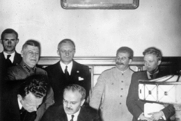 Soviet Commissar for Foreign Affairs Vyacheslav Mikhailovich Molotov, seated, signs the German-Soviet non-aggression pact in Moscow, August 23, 1939, a few days before the outbreak of World War II. Standing behind him are General Secretary of the Communist Party Josef Stalin, second from right, and German Reich Foreign Minister Joachim von Ribbentrop, third from right. Others are unidentified. (AP Photo/German War Department)