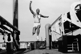 The 1936 Summer Olympic Games opened in Berlin, Germany on Aug. 1. The opening was presided over by Adolf Hitler. Seen here is Jesse Owens, U.S. Olympic sprint and jumping star, as he takes a practice broad jump aboard the S.S. Manhattan at sea, while en route to games a few days before. (AP Photo/Joe Caneva)
