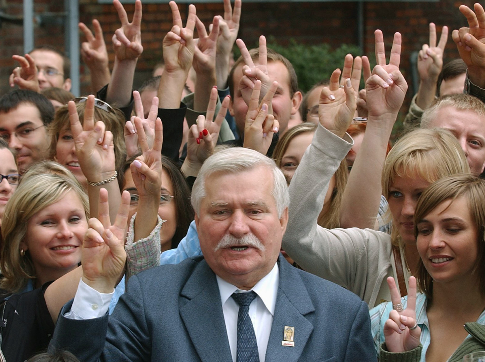 Poland's former president and Solidarity founder Lech Walesa, center, flashes the Victory sign with some 200 young Poles born on Aug. 31, 1980, the day when the Solidarity freedom movement was born out of worker protests in the shipyards on the Baltic coast, including  Gdansk. Walesa attended a special birthday party for the young people at the Gdansk shipyard, Poland, on Tuesday, Aug. 30, 2005 as part of Solidarity 25th anniversary celebrations. ( AP Photo/Czarek Sokolowski)
