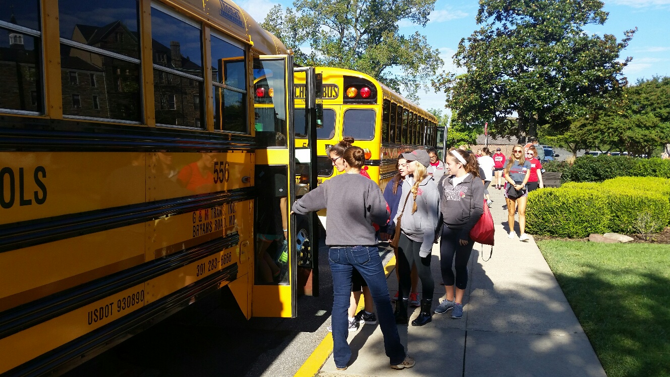 Preparing to go out and serve the community, volunteers board buses at Catholic University of America on Sunday, Sept. 13, 2015, taking action on the "Walk with Francis" pledge. (WTOP/Kathy Stewart)