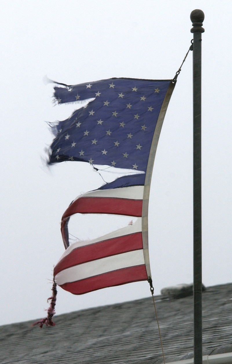 A tattered American Flag flaps in the strong  wind and rain of Hurricane Isabel in the Sandbridge area of Virginia Beach, Va., Thursday Sept. 18, 2003. Hurricane Isabel is expected to make landfall later in the day.   (AP Photo/Steve Helber)