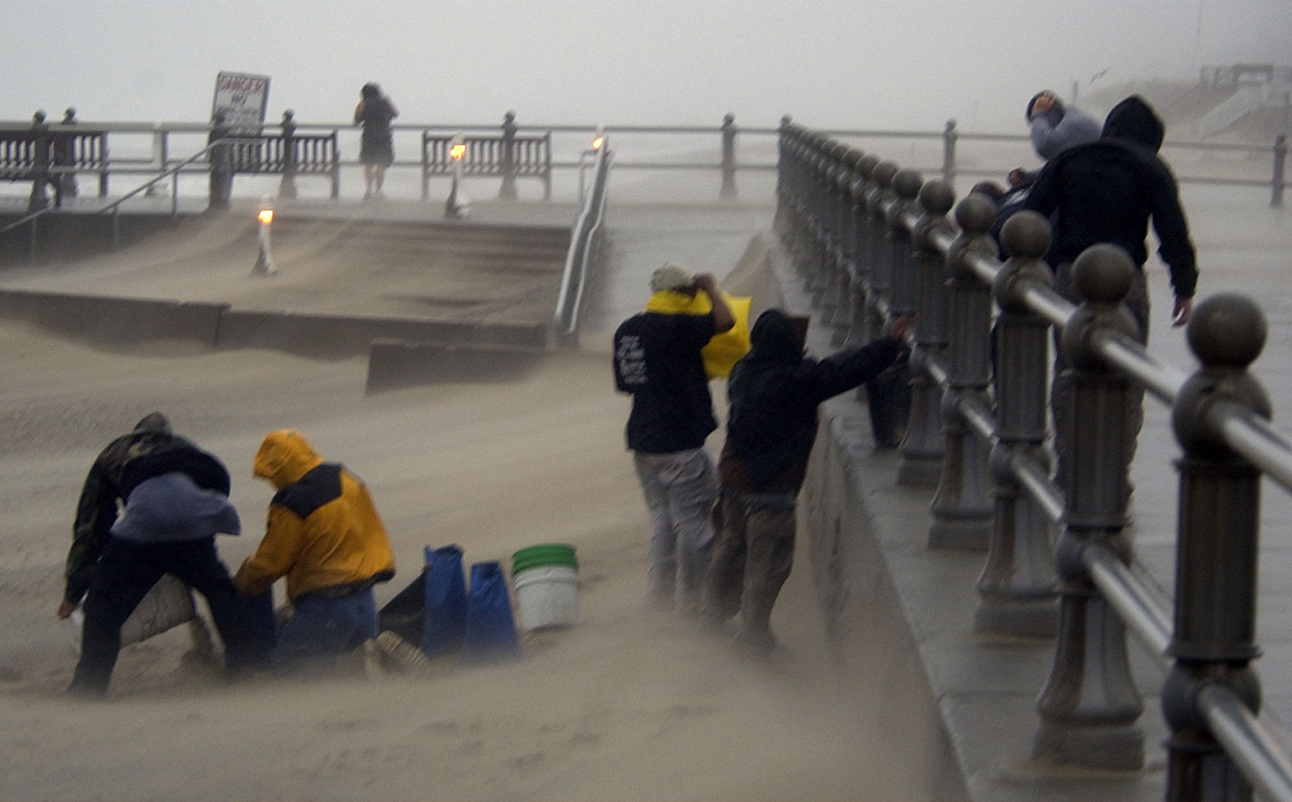 A cleanup crew loads sandbags in the blowing wind and rain on the oceanfront in Virginia Beach, Va., Thursday Sept. 18, 2003. Hurricane Isabel is expected to make landfall later in the day.   (AP Photo/Steve Helber)