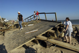 Local residents walk over a section of Harrison fishing pier that washed ashore on the beach in the Ocean View area of Norfolk, Va., Friday Sept. 19, 2003. The pier was built in the 1940's and was destroyed by Hurricane Isabel.  The storm battered the area leaving over 3.5 million people without power.   (AP Photo/Steve Helber)