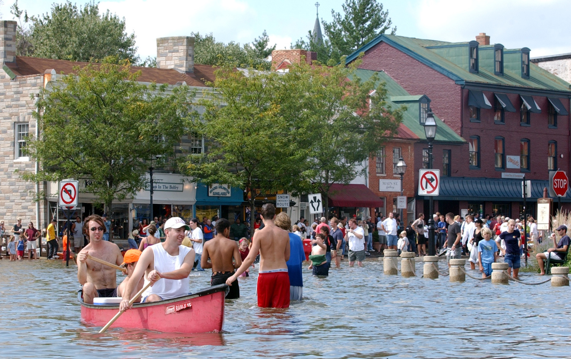 Dozens of people gather in flooded downtown Annapolis, Md., Friday, Sept. 19, 2003, to see the water damage from Hurricane Isabel. Rising tides fed by high winds and rains from Isabel pushed water inland to low-lying areas around the Chesapeake Bay and Potomac River early Friday, flooding homes and businesses. Tidal surges up to 7 feet were expected in some areas of southern Maryland, where high tides began late in the night.(AP Photo/Susan Walsh)