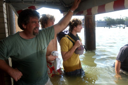 The day after fighting the flood waters of Hurricane Isabel, an uncertain Sveinn Storm, left, stands in the doorway of his ice cream shop on Annapolis City Dock Friday Sept. 19, 2003 in Annapolis, Md.  With Isabel being his fourth storm since opening the shop, Storm is unable to get flood insurance. (AP Photo/Don Wright)