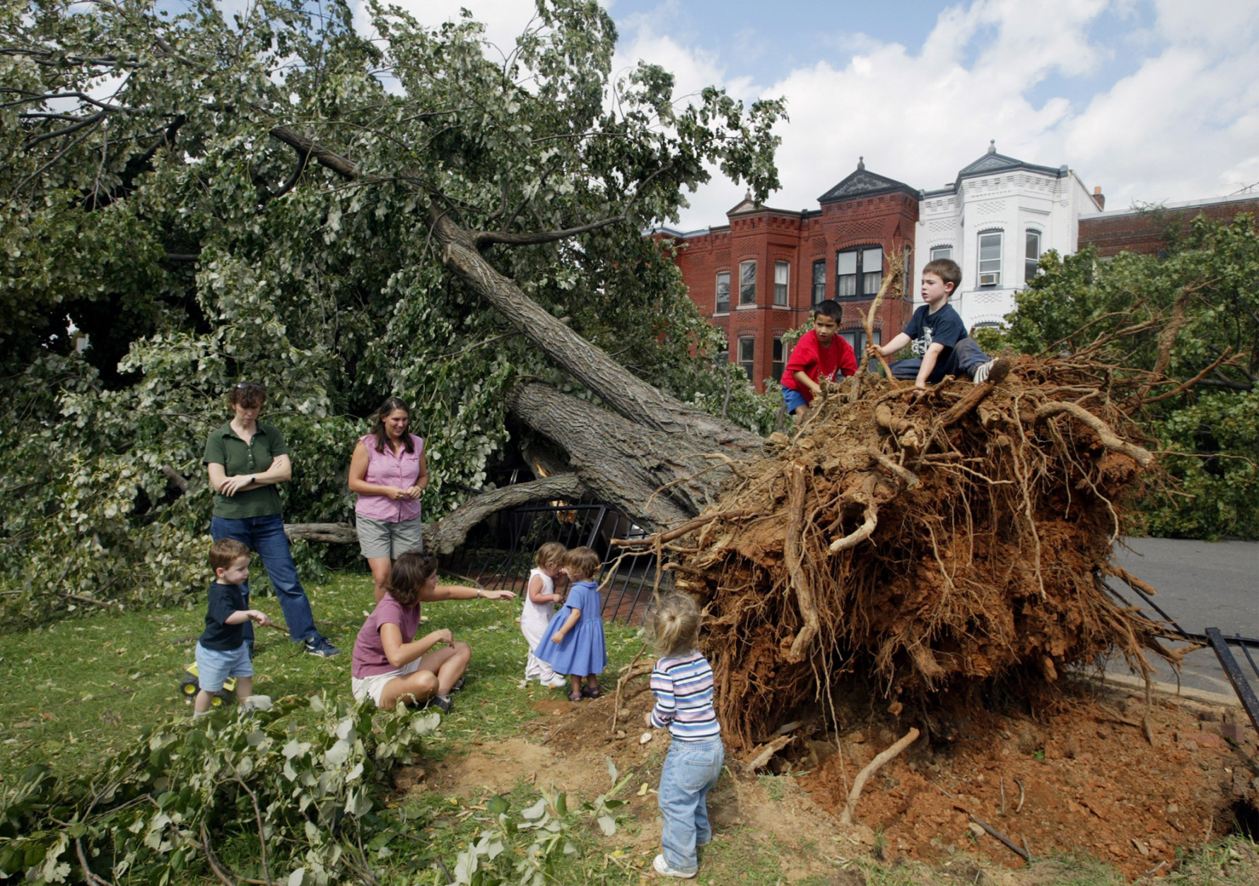 Southeast Washington residents and their children survey a fallen tree from Hurricane Isabel Friday, Sept. 19, 2003. The capital city suffered from a rare power vacuum Friday. Thousands of residents were without lights, hundreds of trees littered the landscape and all three branches of government were basically shut down. Lights were out at the Supreme Court and federal offices; President Bush remained at his secluded mountaintop retreat in Maryland and members of Congress for the most part stayed out of town. (AP Photo/Evan Vucci)