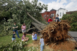 Southeast Washington residents and their children survey a fallen tree from Hurricane Isabel Friday, Sept. 19, 2003. The capital city suffered from a rare power vacuum Friday. Thousands of residents were without lights, hundreds of trees littered the landscape and all three branches of government were basically shut down. Lights were out at the Supreme Court and federal offices; President Bush remained at his secluded mountaintop retreat in Maryland and members of Congress for the most part stayed out of town. (AP Photo/Evan Vucci)