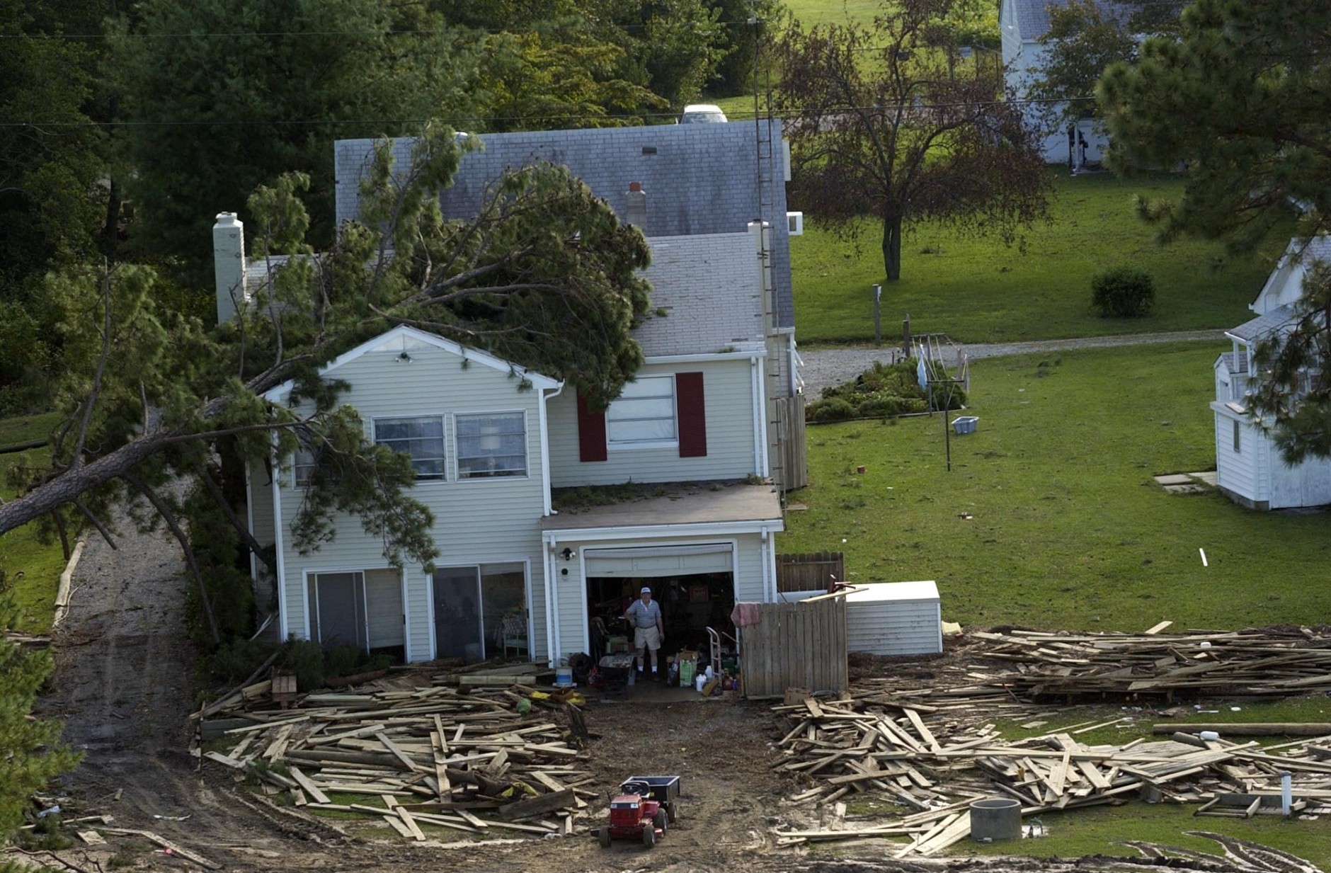 A man stands amidst damage to a home from Hurricane Isabel, which passed through the Church View, Va. area yesterday, on the banks of the Rappahannock River, Friday, Sept. 19, 2003. (AP Photo/Gerald Herbert)