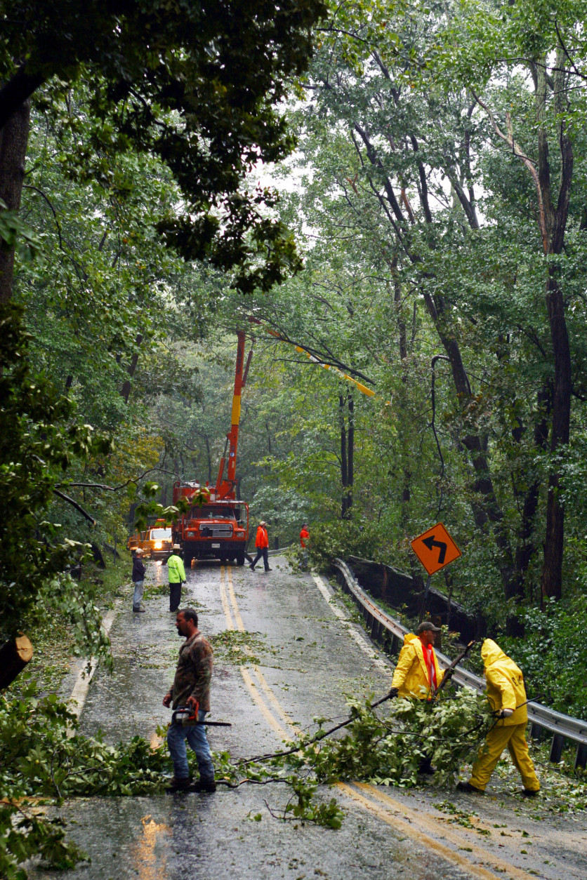 Maryland State Highway crews and employees of R&amp;K Tree services remove downed trees Friday, Sept. 19, 2003 along Maryland 77 west of Thurmont, Md., in the aftermath of Hurricane Isabel. The 10-mile section of mountainous road near Camp David was one of only a few hard hit areas in Frederick County. (AP Photo/Timothy Jacobsen)
