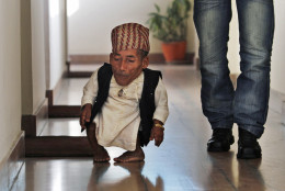 Nepal's Chandra Bahadur Dangi, 72, who says he's only 22 inches (56 centimeters) tall walks in a guesthouse just hours before he was to be measured by officials, in Katmandu, Nepal, Sunday, Feb. 26, 2012. Guinness World Records officials were set to measure Dangi hopes to be named the world's shortest man later Sunday. Dangi is hoping to snatch the title of the world's shortest man from Junrey Balawing of the Philippines, who is 23.5 inches (60 centimeters) tall. (AP Photo/Niranjan Shrestha)