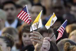 Spectators hoping for a glimpse of Pope Francis waves Papal and U.S. Flags on the South Lawn of the White House in Washington, Wednesday, Sept. 23, 2015, before the official state arrival ceremony where President Barack Obama will welcome the pope. (AP Photo/Pablo Martinez Monsivais)