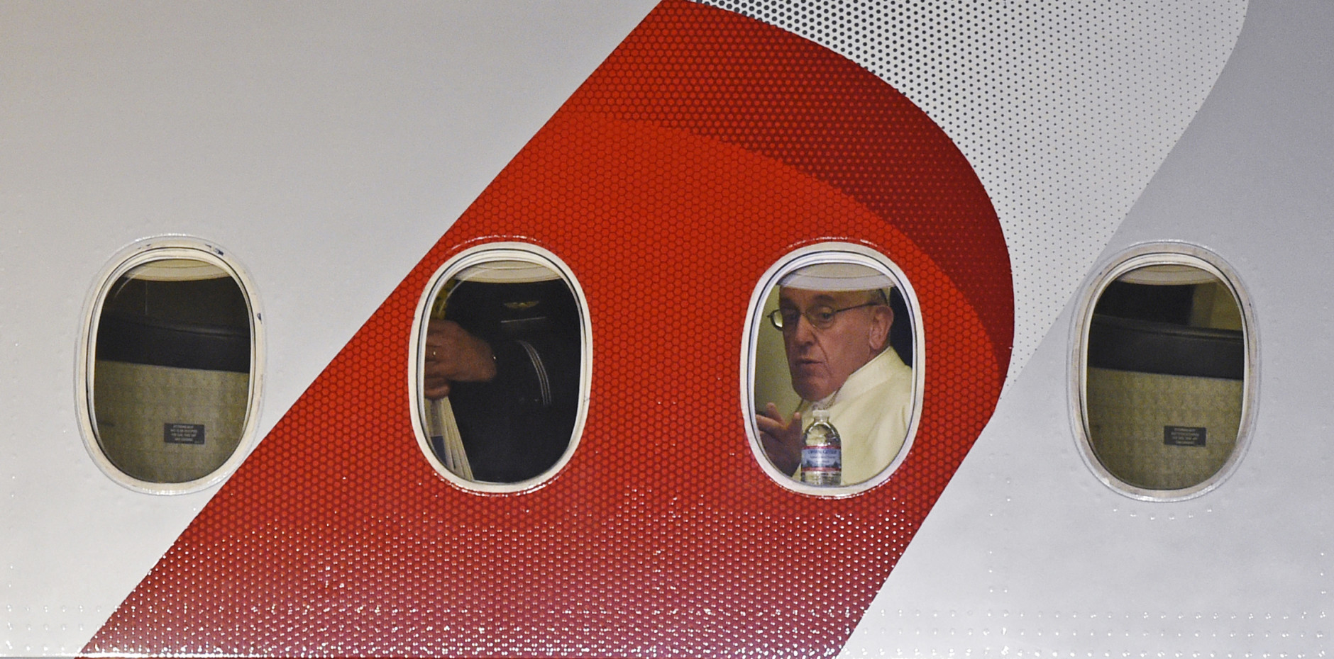 Pope Francis looks out the window a plane as he prepares to depart Philadelphia International Airport in Philadelphia, Sunday, Sept. 27, 2015, on his way back to Rome. Pope Francis wrapped up his 10-day trip to Cuba and the United States on Sunday. (AP Photo/Susan Walsh)