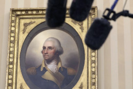 A portrait of George Washington and media microphones are seen in the Oval Office in Washington, Friday, Sept. 16, 2016, as President Barack Obama talks to media at the start of a meeting with business, government, and national security leaders on how the Trans-Pacific Partnership can benefit American workers and businesses and further national security. (AP Photo/Carolyn Kaster)