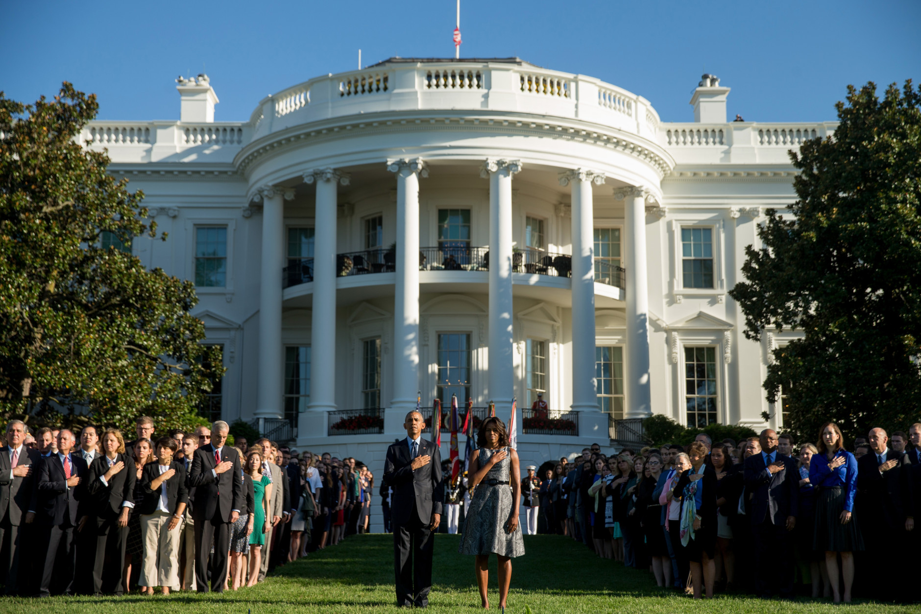 President Barack Obama, first lady Michelle Obama, and other, pause on the South Lawn of the White House in Washington, Friday, Sept. 11, 2015, as a bugler plays "taps" to mark the 14th anniversary of the 9/11 attacks. (AP Photo/Andrew Harnik)