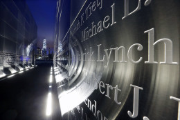 The names are seen on the "Empty Sky" memorial to New Jersey's victims of the Sept. 11, 2001 terrorist attacks, as One World Trade Center, center left, stands on the 14th anniversary, early Friday, Sept. 11, 2015, in Jersey City, N.J.  Victims' relatives began marking the 14th anniversary of Sept. 11 in a subdued gathering Friday at ground zero, with a moment of silence and somber reading of names. (AP Photo/Mel Evans)