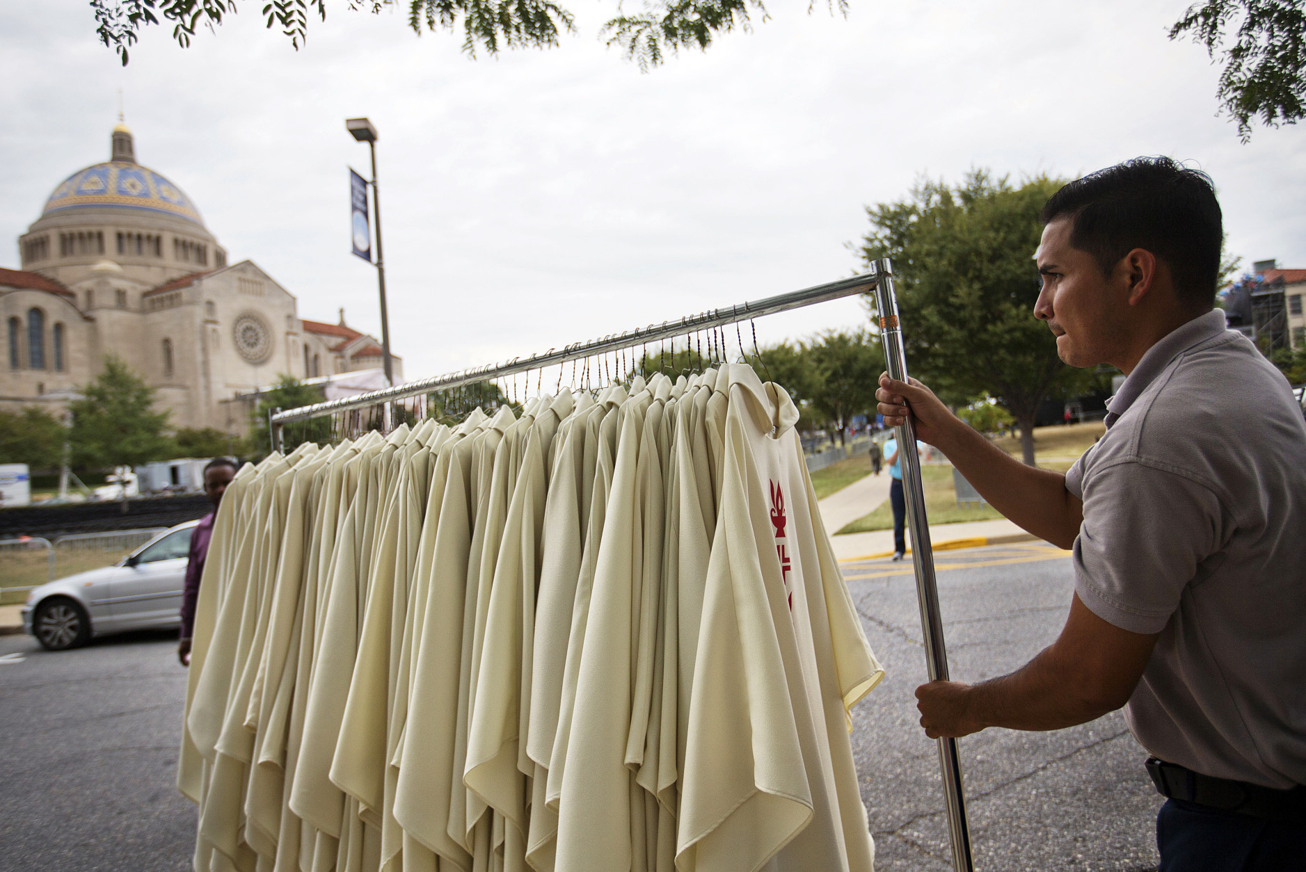 A worker pulls a rack of vestments to be worn by priests at Wednesday's Mass with Pope Francis during preparations at the Basilica of the National Shrine of the Immaculate Conception, rear, Monday, Sept. 21, 2015, in Washington. Pope Francis will celebrate Mass Wednesday at the basilica, the largest Catholic church in the United States and North America, with a crowd of about 30,000. (AP Photo/David Goldman)