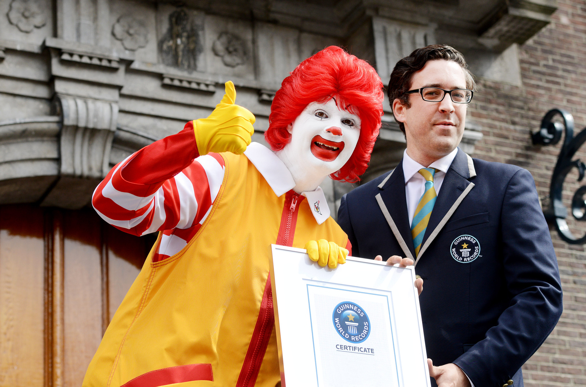 IMAGE DISTRIBUTED FOR MCDONALD'S - Jack Brockbank, Guinness World Records judge, is presented a certificate at the McDonald's and Guinness World Records event during Redhead Festival in Breda, The Netherlands on Sunday, Sept. 1, 2013. 1,672 redheads, accompanied by famous redhead Ronald McDonald, set the Guinness World Record for the largest gathering of redheads at the 2013 Redhead Days Festival. More than 5,000 redheads attended the global event from 80 countries. Throughout the weekend, Ronald McDonald served as the Redhead Days official ambassador by delivering smiles to many people.  McDonalds is making a $1 donation to Ronald McDonald House Charities (up to $10,000 USD) for every person who changes their Facebook or Twitter profile picture using www.mcdonalds.com/mcdsmiles, #mcdsmiles. (Patrick Post/AP Images for McDonald's)