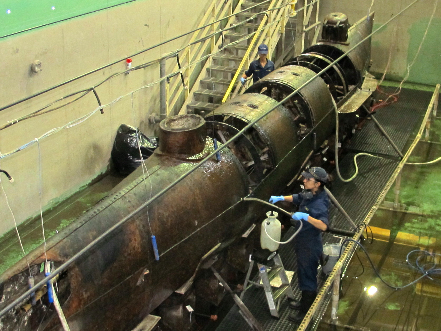 The Confederate submarine H.L. Hunley, the first submarine in history to sink an enemy warship, sits in a conservation tank at a lab in North Charleston, S.C. on Thursday, Sept. 17, 2015. Scientists have just completed a year of painstaking work to remove the encrusted sediment and rust from the outer hull of the submarine. But they say cleaning the hull provided no smoking gun as to why the hand-cranked submarine sank in February of 1864 after sinking a Union blockade ship off Charleston, S.C. (AP Photo/Bruce Smith)