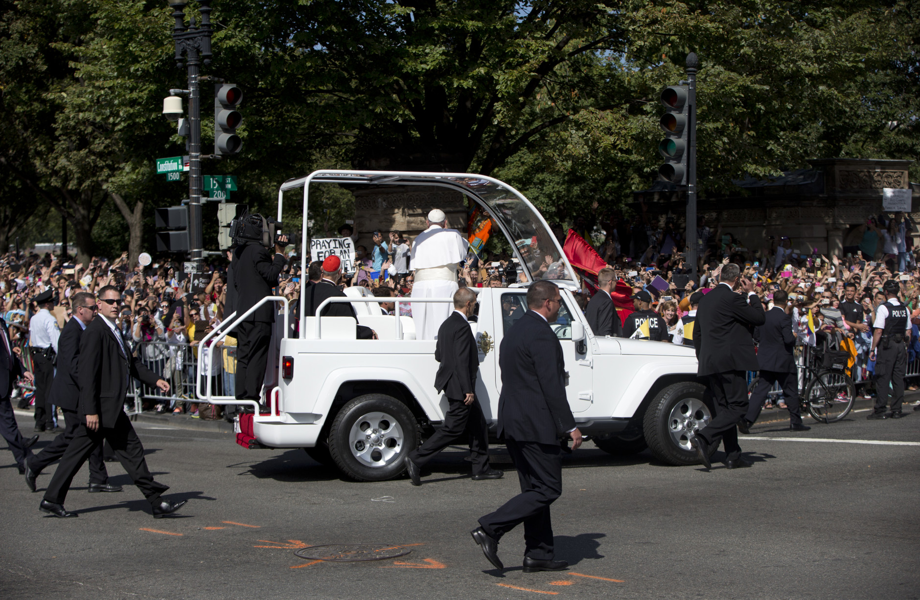 Pope Francis waves to the crowd from his popemobile at the corner of Constitution Avenue and 15th Street NW, during a parade around the Ellipse near the White House in Washington, Wednesday, Sept. 23, 2015. (AP Photo/Carolyn Kaster)