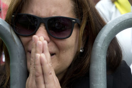A tear runs down the face of Milagros Orengo of Egg Harbor N.J., and born in the Dominican Republic, as she prays behind a barricade at Independence Mall in Philadelphia, as a Mass with Pope Francis at the Cathedral Basilica of Sts. Peter and Paul is projected on a large screen, Saturday, Sept. 26, 2015. (AP Photo/Carolyn Kaster)