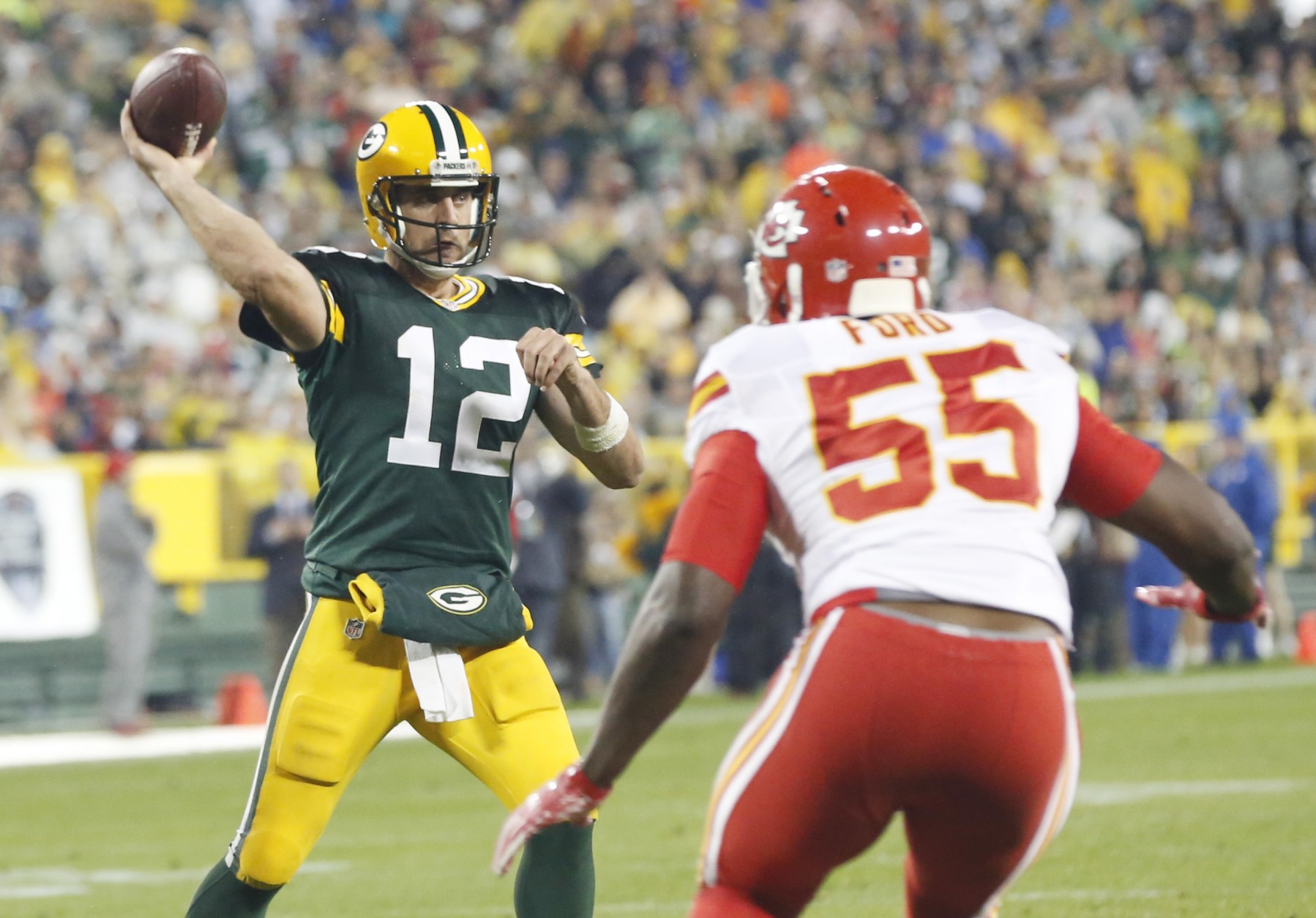 Green Bay Packers' Aaron Rodgers throws with Kansas City Chiefs' Dee Ford (55) rushing during the second half of an NFL football game Monday, Sept. 28, 2015, in Green Bay, Wis. (AP Photo/Mike Roemer)