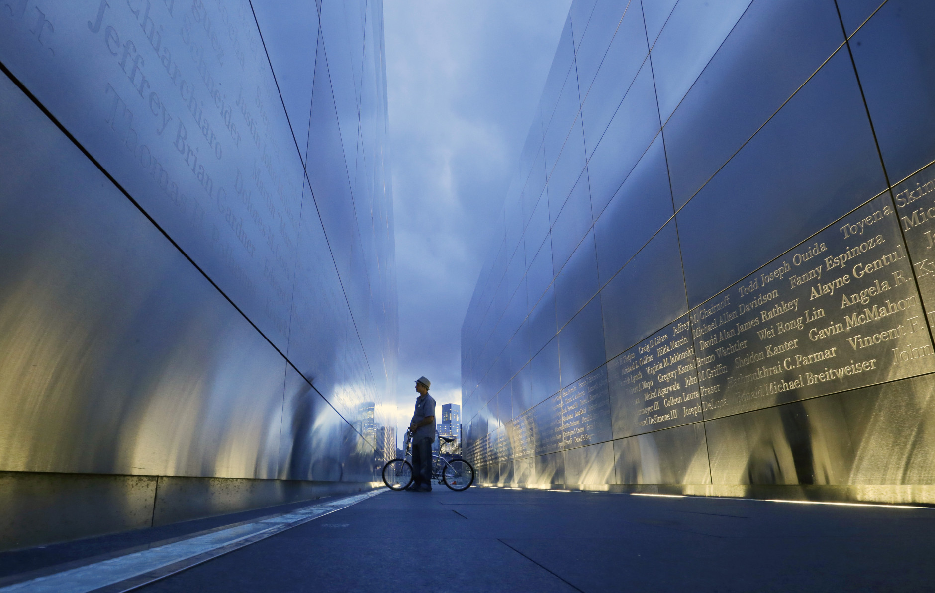 Tamir Rivera, of Newark, N.J., pauses to look at the names on the "Empty Sky" memorial to New Jersey's victims of the Sept. 11, 2001 terrorist attacks early Friday, Sept. 11, 2015, in Jersey City, N.J.  Victims' relatives began marking the 14th anniversary of Sept. 11 in a subdued gathering Friday at ground zero, with a moment of silence and somber reading of names. (AP Photo/Mel Evans)