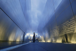 Tamir Rivera, of Newark, N.J., pauses to look at the names on the "Empty Sky" memorial to New Jersey's victims of the Sept. 11, 2001 terrorist attacks early Friday, Sept. 11, 2015, in Jersey City, N.J.  Victims' relatives began marking the 14th anniversary of Sept. 11 in a subdued gathering Friday at ground zero, with a moment of silence and somber reading of names. (AP Photo/Mel Evans)