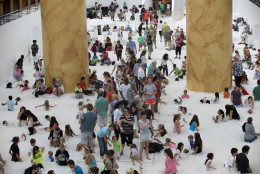 Children and adults play at "The Beach", an interactive architectural installation inside the National Building Museum in Washington, Wednesday, July 29, 2015. The Beach, which spans the length of the museum's Great Hall, was created in partnership with Snarkitecture, and covers 10,000 square feet and includes an ocean of nearly one million recyclable translucent plastic balls.   (AP Photo/Carolyn Kaster)