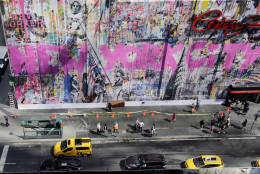 Pedestrians and traffic pass a painting titled "New York City Is Beautiful" on the side of a department store, Wednesday, Sept. 9, 2015 in New York. Century 21 commissioned the street artist Mr. Brainwash to create the piece as a tribute to the Sept. 11, 2001, terrorist attacks. (AP Photo/Mark Lennihan)