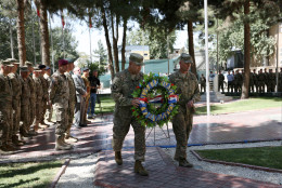 Commander of the International Security Assistance Force (ISAF), Gen. John Campbell, left, and Command Sergeant Major Delbert Byers, right, carry a wreath during a memorial ceremony on the fourteenth anniversary of the 9-11 terrorist attacks on the United States at the headquarters of the International Security Assistance Force, in Kabul, Afghanistan, Friday, Sept. 11, 2015. (AP Photo/Rahmat Gul)