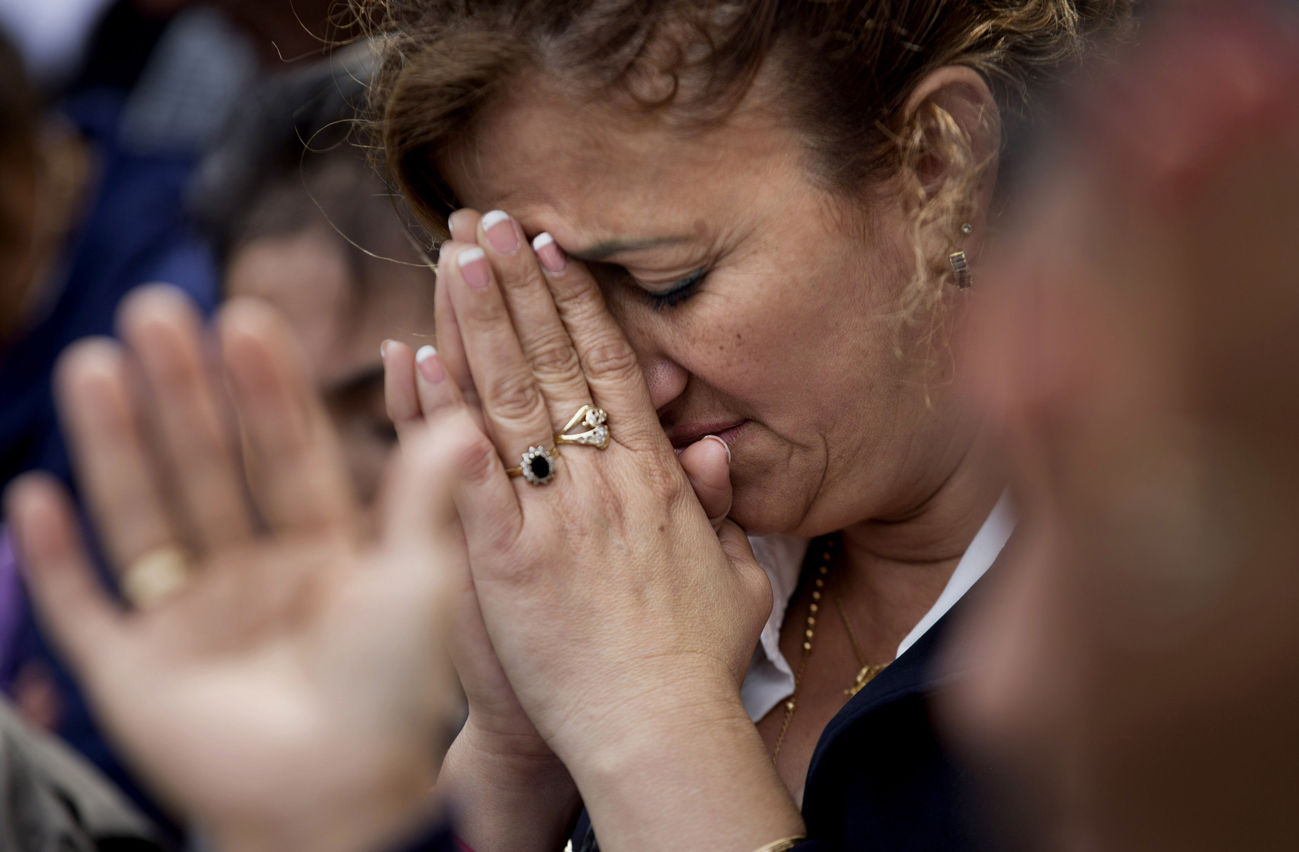 Pilar Cedeno, of Hackensack, N.J., prays as Mass conducted by Pope Francis is broadcast to crowds on the Benjamin Franklin Parkway from inside the Cathedral Basilica of Saints Peter and Paul Saturday, Sept. 26, 2015, in Philadelphia. (AP Photo/David Goldman)