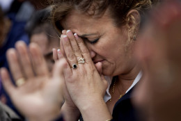 Pilar Cedeno, of Hackensack, N.J., prays as Mass conducted by Pope Francis is broadcast to crowds on the Benjamin Franklin Parkway from inside the Cathedral Basilica of Saints Peter and Paul Saturday, Sept. 26, 2015, in Philadelphia. (AP Photo/David Goldman)