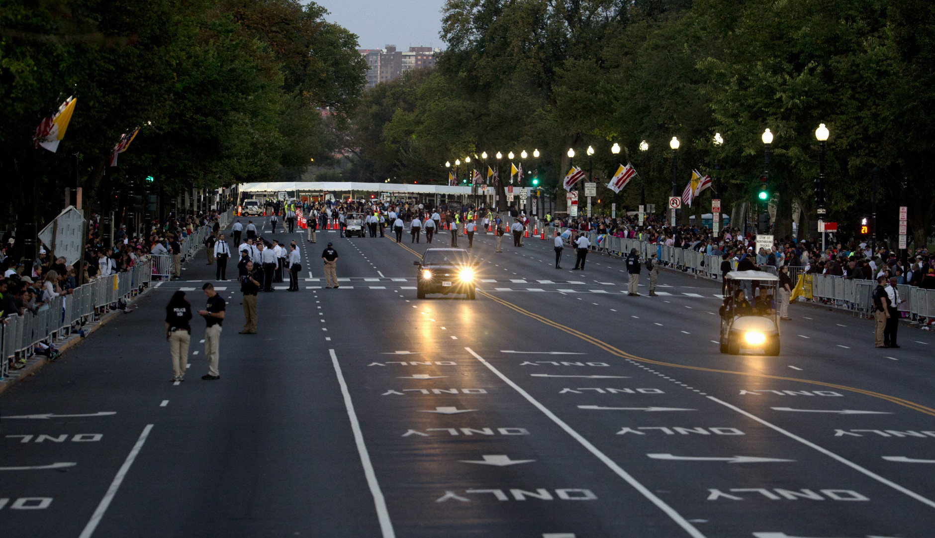 People position along a cleared Constitution Avenue along the Pope Francis parade route near the White House in Washington, Wednesday, Sept. 23, 2015. (AP Photo/Carolyn Kaster)