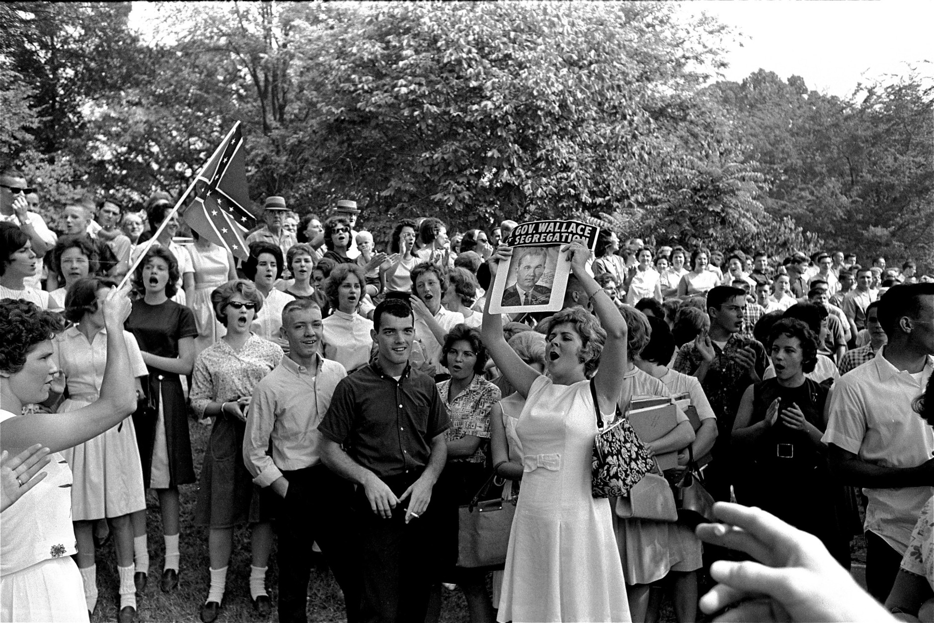 On this date in 1963, 20 black students entered Alabama public schools following a standoff between federal authorities and Gov. George C. Wallace. Here, students West End High yell, wave flags and a picture of Wallace as they demonstrate at Birmingham, Ala., following admittance of two black students, Sept. 10, 1963.  (AP Photo/stf)