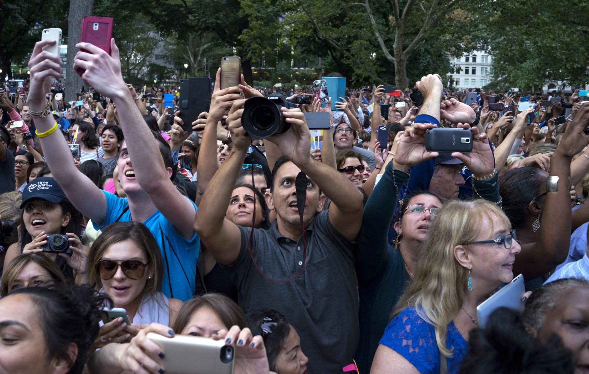Well-wishers stretch to take photos as Pope Francis passed by while traveling in a motorcade in New York's Central Park, Friday, Sept. 25, 2015. (AP Photo/Craig Ruttle)